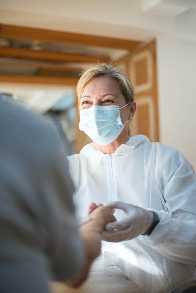 a woman in home nursing equipment is talking to an elderly person.